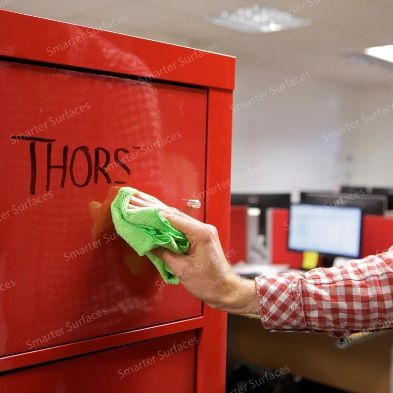 Person writing on a red cabinet protected with clear whiteboard film