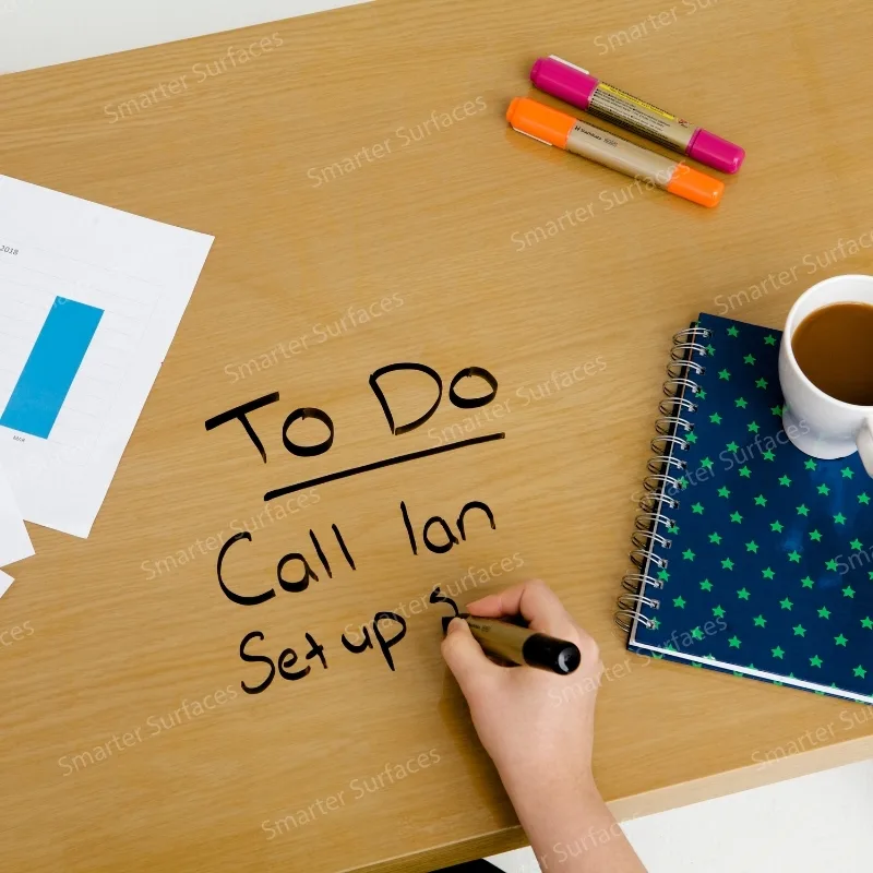 Handwriting a to-do list on a desk covered with clear dry-erase film