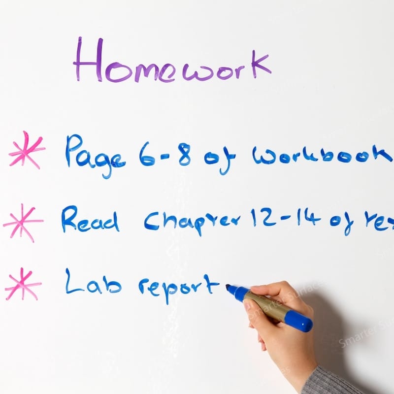 Hand writing homework checklist on best dry erase wallpaper with blue and pink markers showing tasks.