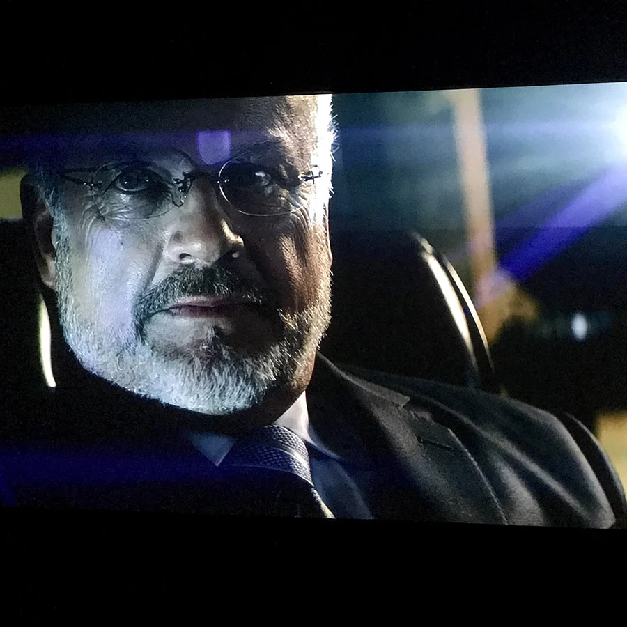 Projected image of Old man’s Face displayed on painted acoustically transparent Screen in a movie