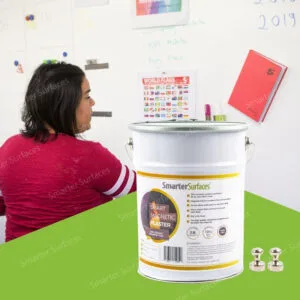 Woman working with magnetic plaster wall displaying colorful notes and calendar on magnetic receptive surface