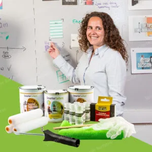 Smiling woman presenting ideas on a wall coated with Smarter Surfaces magnetic whiteboard paint clear