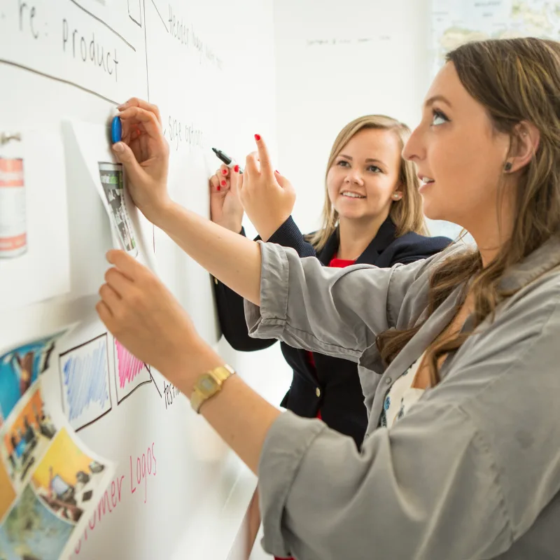 Professional Women Collaborating on Business Strategy using Magnetic Whiteboard Paint