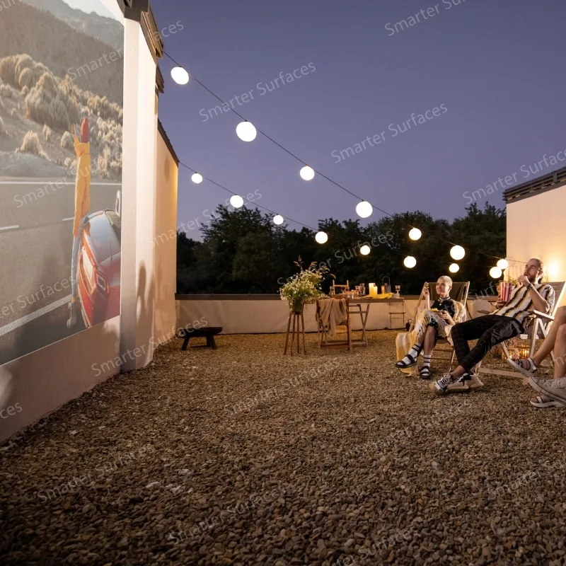 Outdoor gathering watching a movie on a painted exterior wall