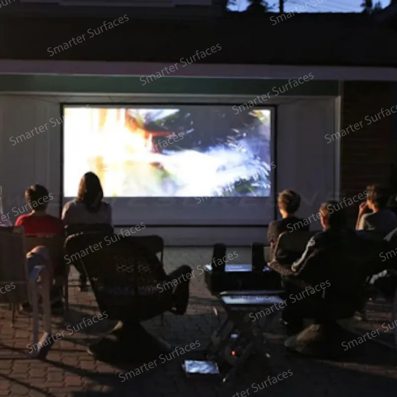 Group watching a movie outdoors at night using a wall painted with projector screen paint