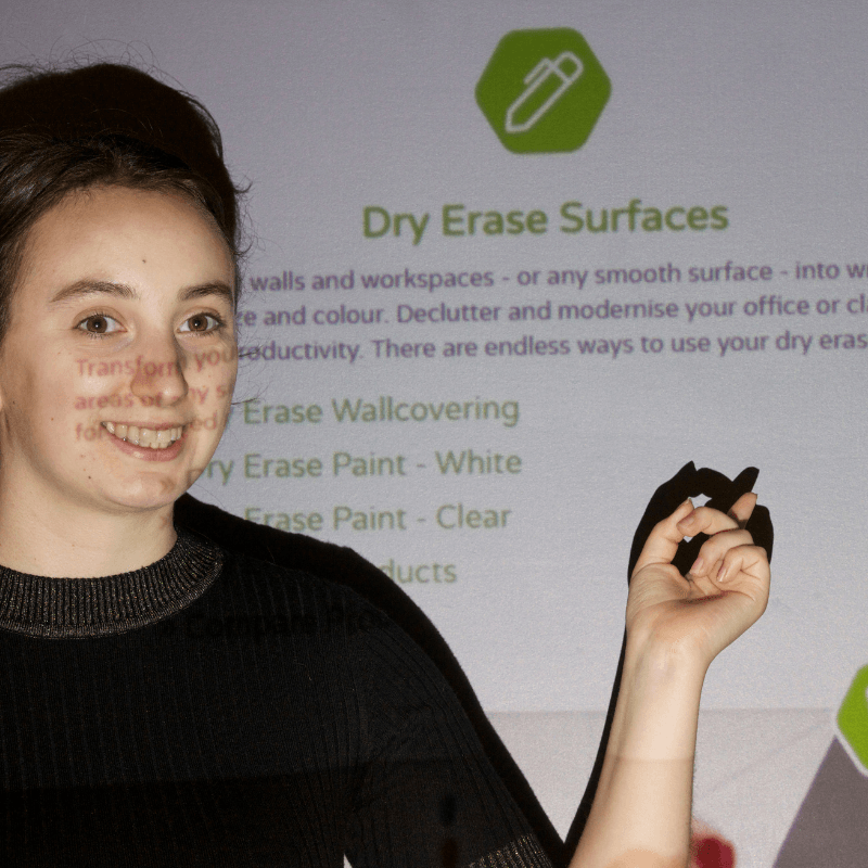 A woman pointing at text projected on a transparent projection surface