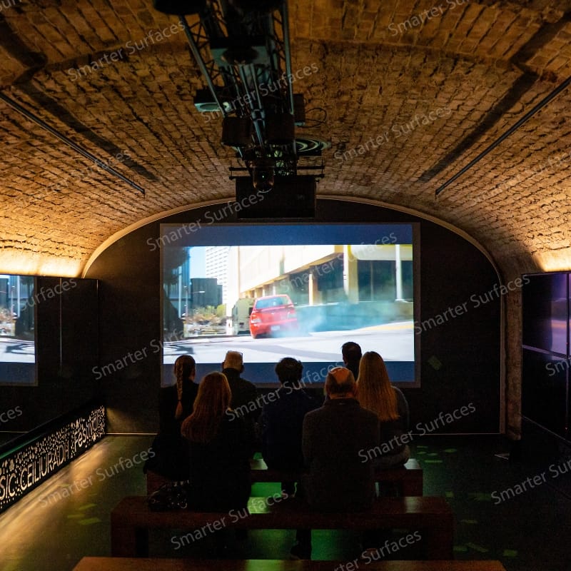 Group watching an immersive projection inside an arched room