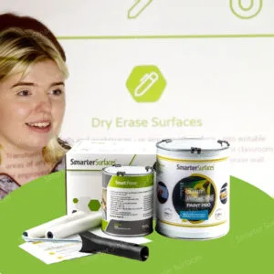 A kid standing beside Smarter Surfaces white projector screen paint products, including paint cans, primer, and application tools displayed on a green background.