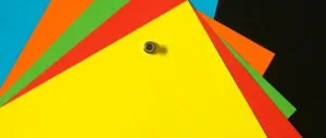 Colourful sheets of paper pinned to a magnetic chalkboard wall.