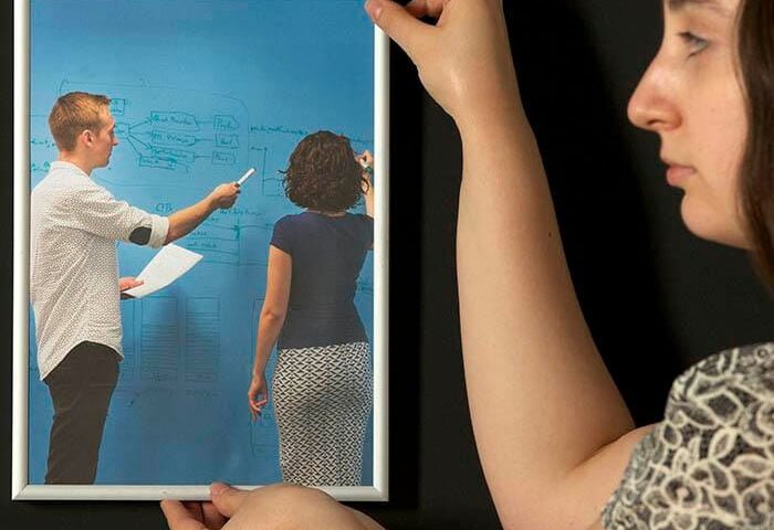 Woman hanging up frame on super magnetic paint coated wall