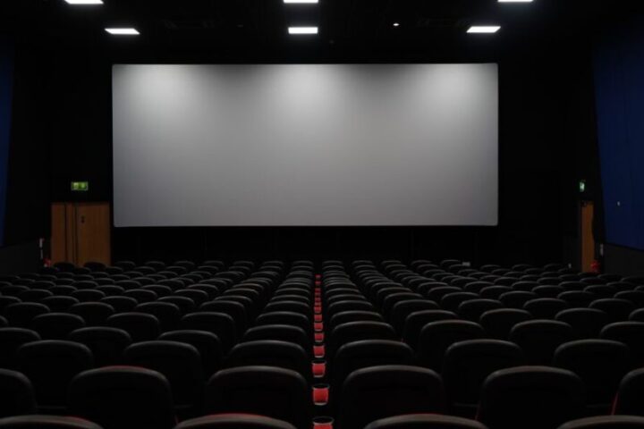 A big painted on acoustically transparent Screen with seating chairs ready for viewing in a dark room