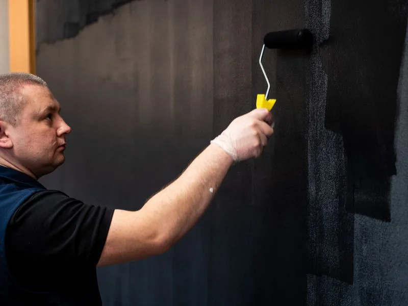 Step 11 - Man applying more coats of magnetic gray paint with roller
