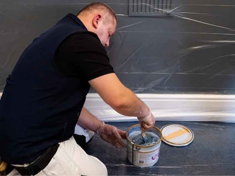 Step 8 - Man using stick to stir magnetic gray paint for 5 minutes