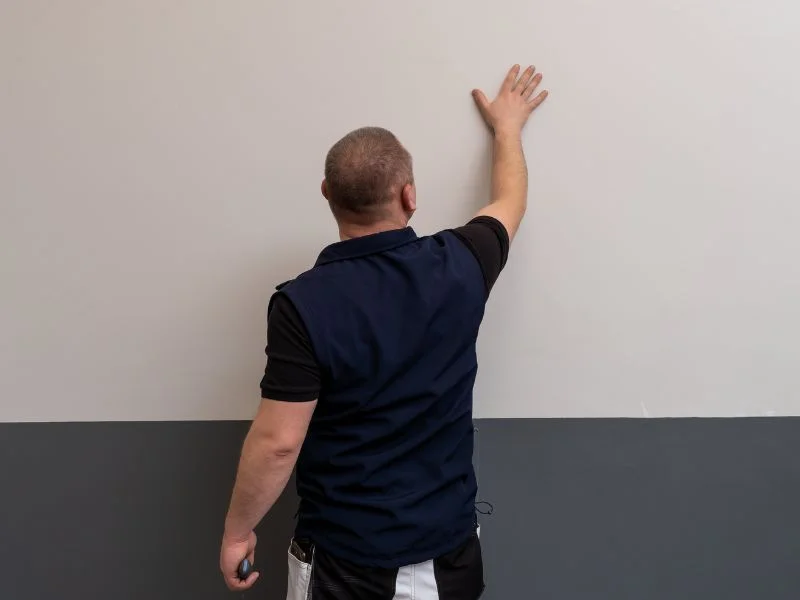 Step 4 - Man preparing surface for applying magnetic gray paint, making sure wall clean and dry and free from holes or cracks