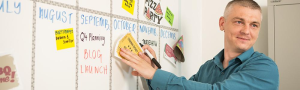 Person attaching a paper on magnetic wall.